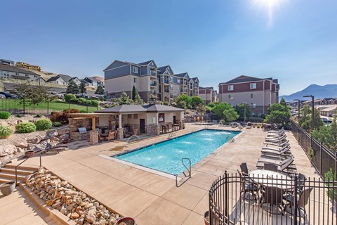 A sunny day at a resort with a pool and a mountain in the background.