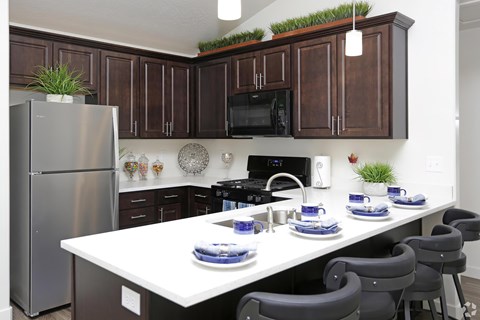 A kitchen with a white table and brown cabinets.