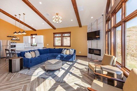 A modern living room with a blue sofa and wooden flooring.