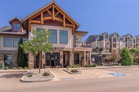 A large building with a wooden front and a parking lot in front.