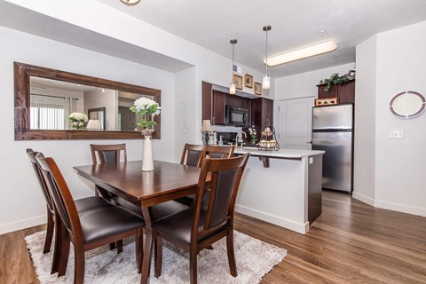 A dining room with a wooden table and chairs.