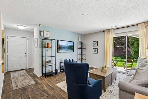 A living room with a blue chair and a grey couch.