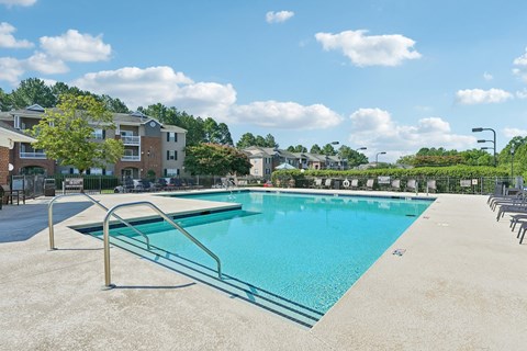 A large swimming pool with a diving board in the middle of it.