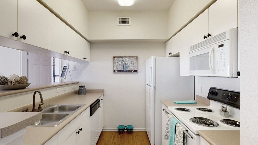 a kitchen with white cabinets and white appliances