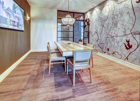 A dining room with a wooden table and chairs.