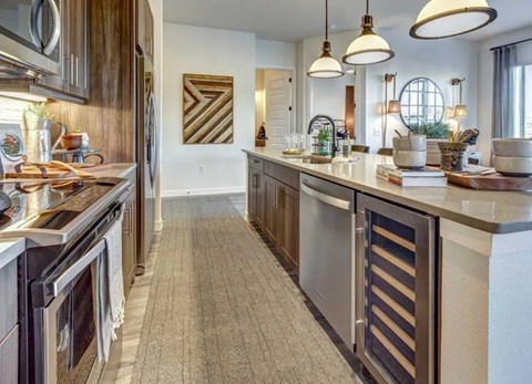 A modern kitchen with dark wood cabinets and stainless steel appliances.