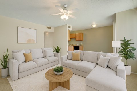 A living room with two couches, a coffee table, and a ceiling fan.