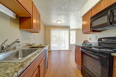 A kitchen with wooden cabinets and a black stove top oven.