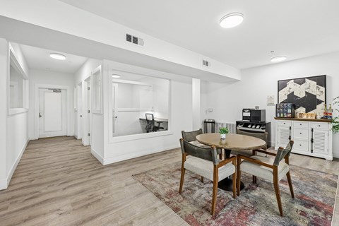 A dining room with a round table and chairs.
