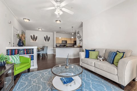 A living room with a white couch and a glass coffee table.