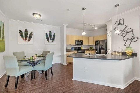 A kitchen with a dining table and chairs.