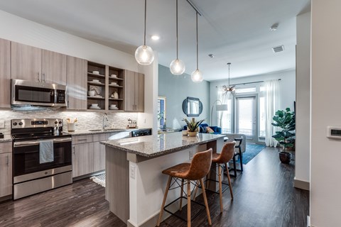 A modern kitchen with a large island and wooden floors.
