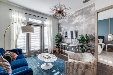 A modern living room with a blue sofa and a round coffee table.