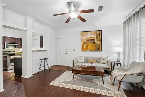 A living room with a brown rug and a brown coffee table.