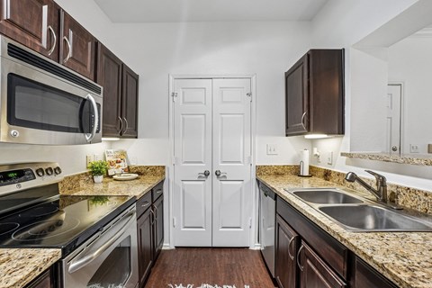 A kitchen with brown cabinets and a white door.