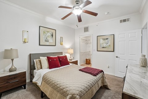 A bedroom with a large bed and a ceiling fan.