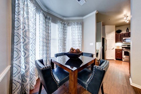 A dining room with a table and chairs.