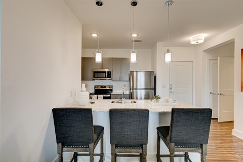 A kitchen with a table and chairs.