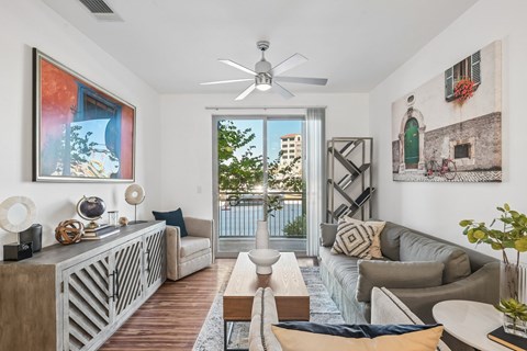 A living room with a couch, a coffee table, and a ceiling fan.