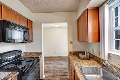 A kitchen with a black microwave above the stove.
