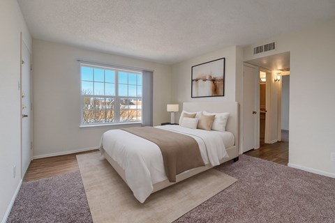 A bedroom with a large bed and a window overlooking the beach.
