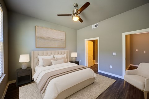 A bedroom with a large bed and a ceiling fan.