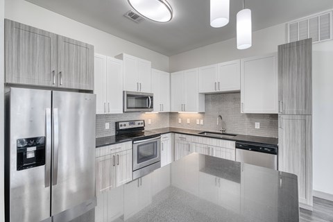 A modern kitchen with stainless steel appliances and white cabinets.