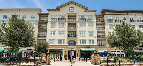 A large building with a clock on the front and a green awning.
