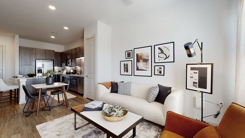 A modern living room with a white sofa, a coffee table, and a dining table with chairs.