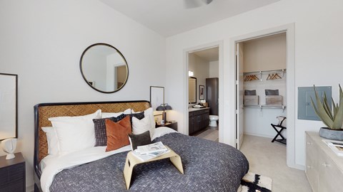 A bedroom with a large bed and a mirror on the wall.