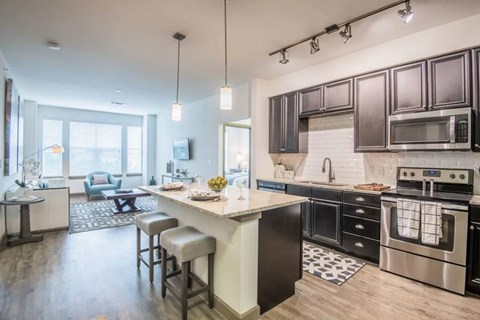 A modern kitchen with dark brown cabinets and a white island.
