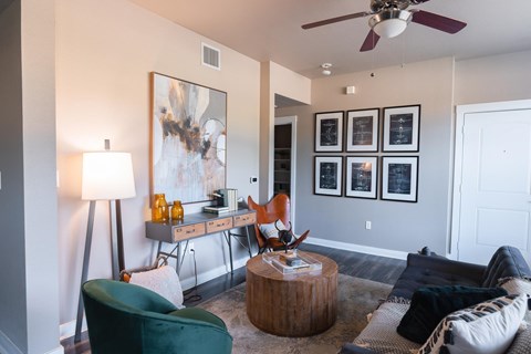 A living room with a green chair and a painting on the wall.
