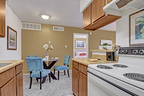 A kitchen with a table and chairs.