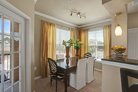 A dining room with a table set for four.