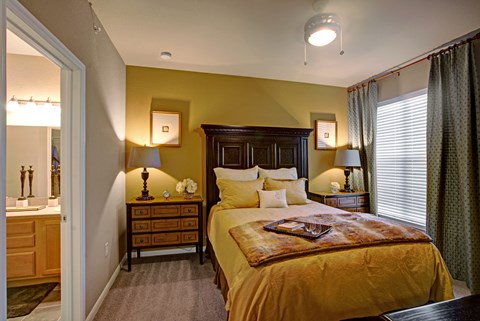 A bedroom with a bed, nightstands, and a dresser.