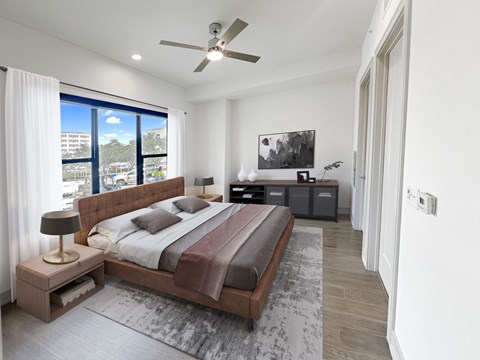 A bedroom with a large bed and a ceiling fan.