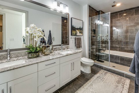A bathroom with a toilet, sink, and shower.