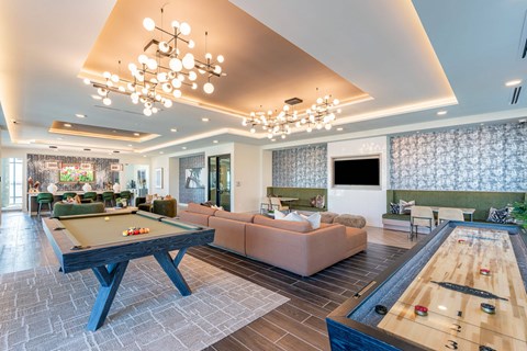 A billiard table is in the middle of a room with a pool table on the right.