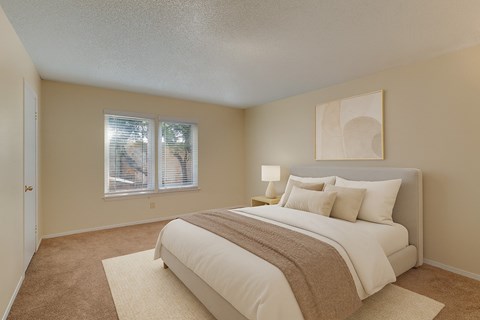 A bedroom with a large bed and a window.