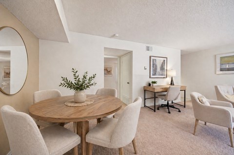 A dining room with a round table and chairs.