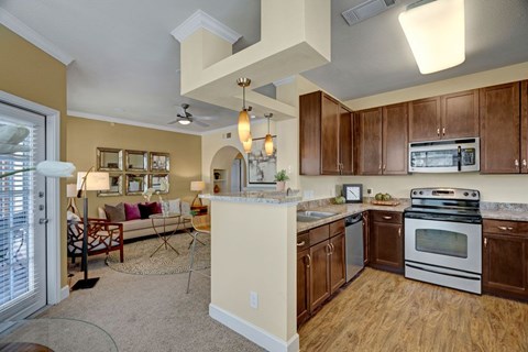 A kitchen with wooden cabinets and a white stove top oven.