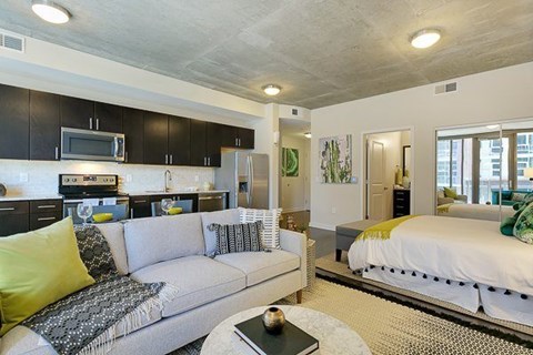 A modern living room with a grey couch and a white coffee table.