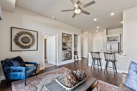 A living room with a blue chair and a woven basket on the coffee table.