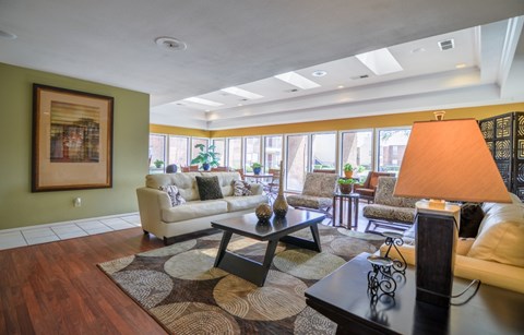 A living room with a couch, coffee table, and a painting on the wall.