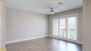 an empty living room with a ceiling fan