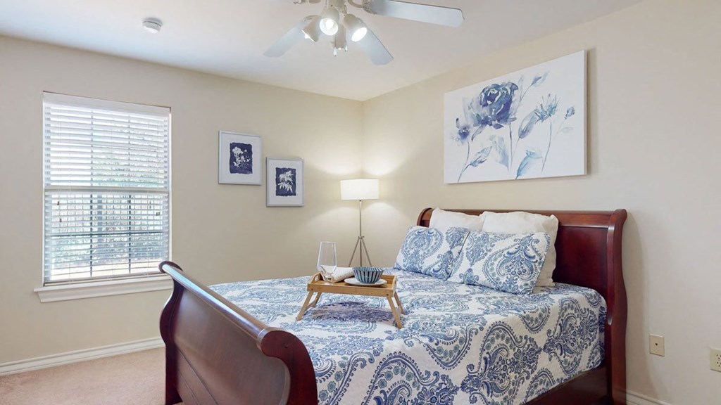 a bedroom with a bed and a ceiling fan