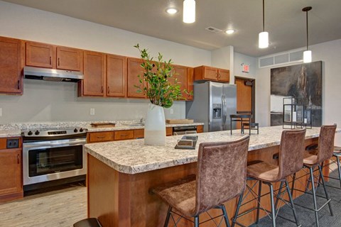 a kitchen with a large counter with chairs