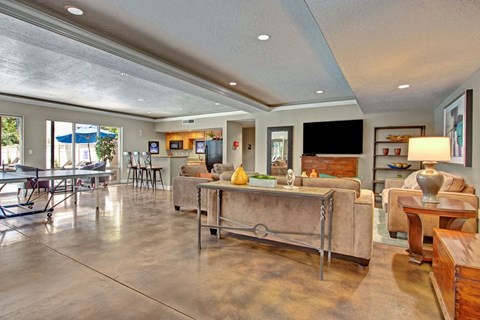 A living room with a couch, a table, and a television.