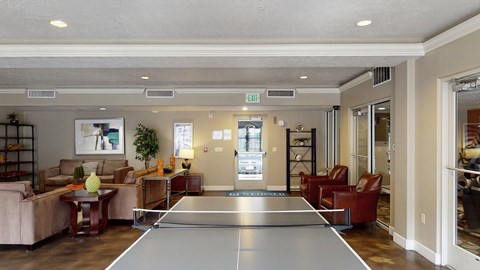 A ping pong table is in the middle of a living room.