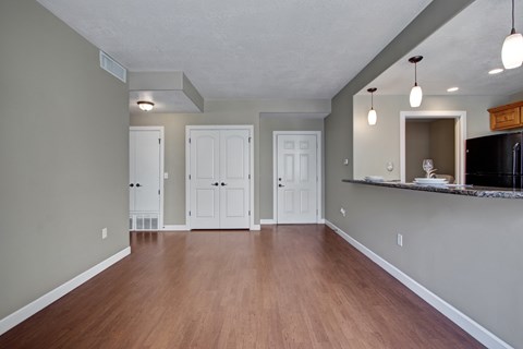 A kitchen area with a refrigerator, microwave, and cabinets.